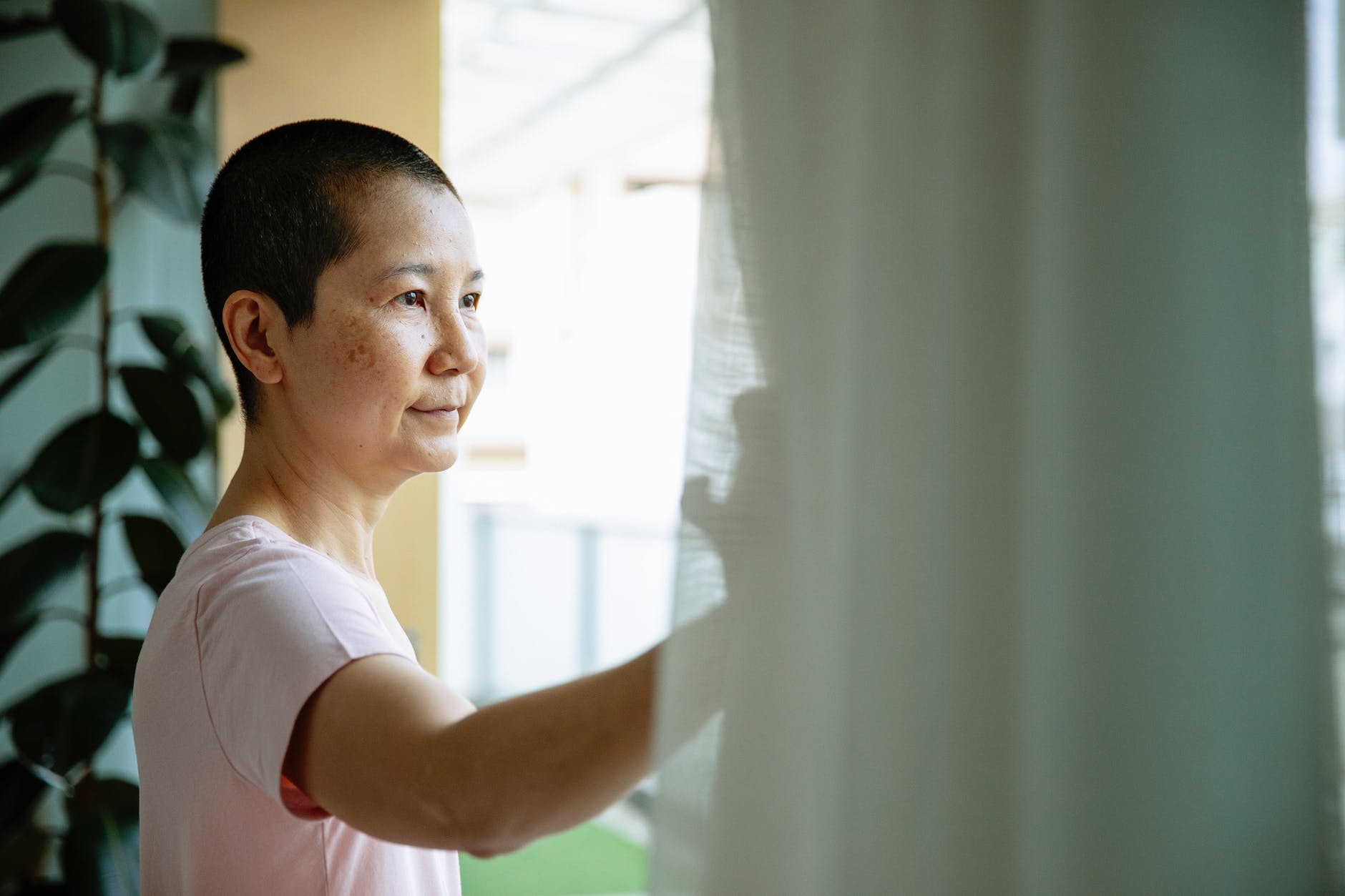 happy asian woman suffering from cancer near window
